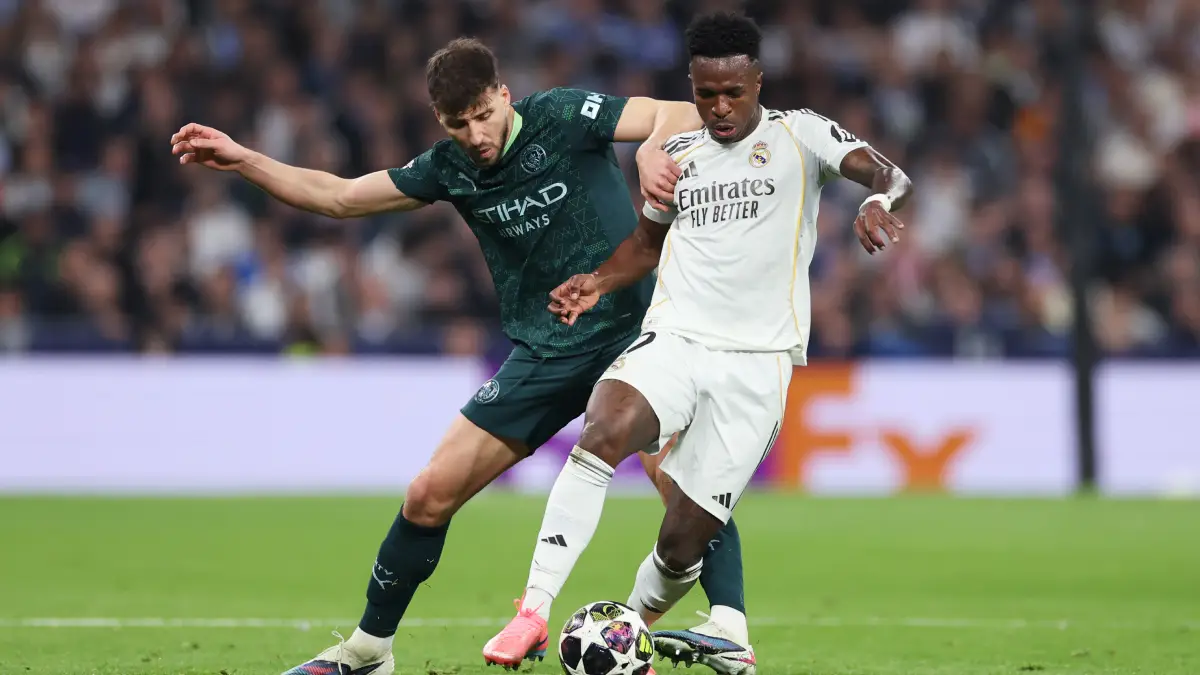 MADRID, SPAIN - MARCH 11: Ruben Dias of Manchester City battles for possession with Vinicius Junior of Real Madrid during the UEFA Champions League 2025/26 Round of 16 First Leg match between Real Madrid CF and Manchester City FC at Estadio Santiago Bernabeu on March 11, 2026 in Madrid, Spain. (Photo by Florencia Tan Jun/Getty Images)