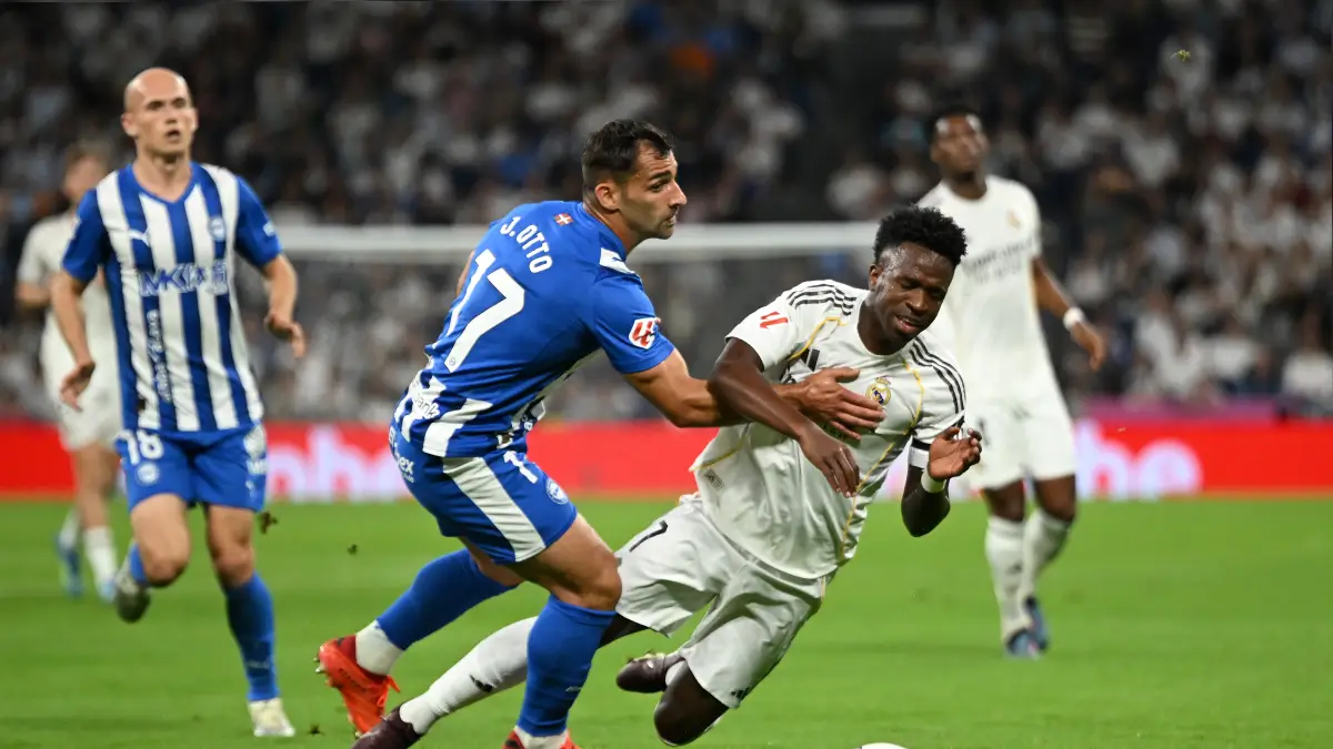 MADRID, SPAIN - APRIL 21: Vinicius Junior of Real Madrid goes down under a challenge from Jonny of Deportivo Alaves during the LaLiga EA Sports match between Real Madrid CF and Deportivo Alaves at Estadio Santiago Bernabeu on April 21, 2026 in Madrid, Spain. (Photo by Denis Doyle/Getty Images)