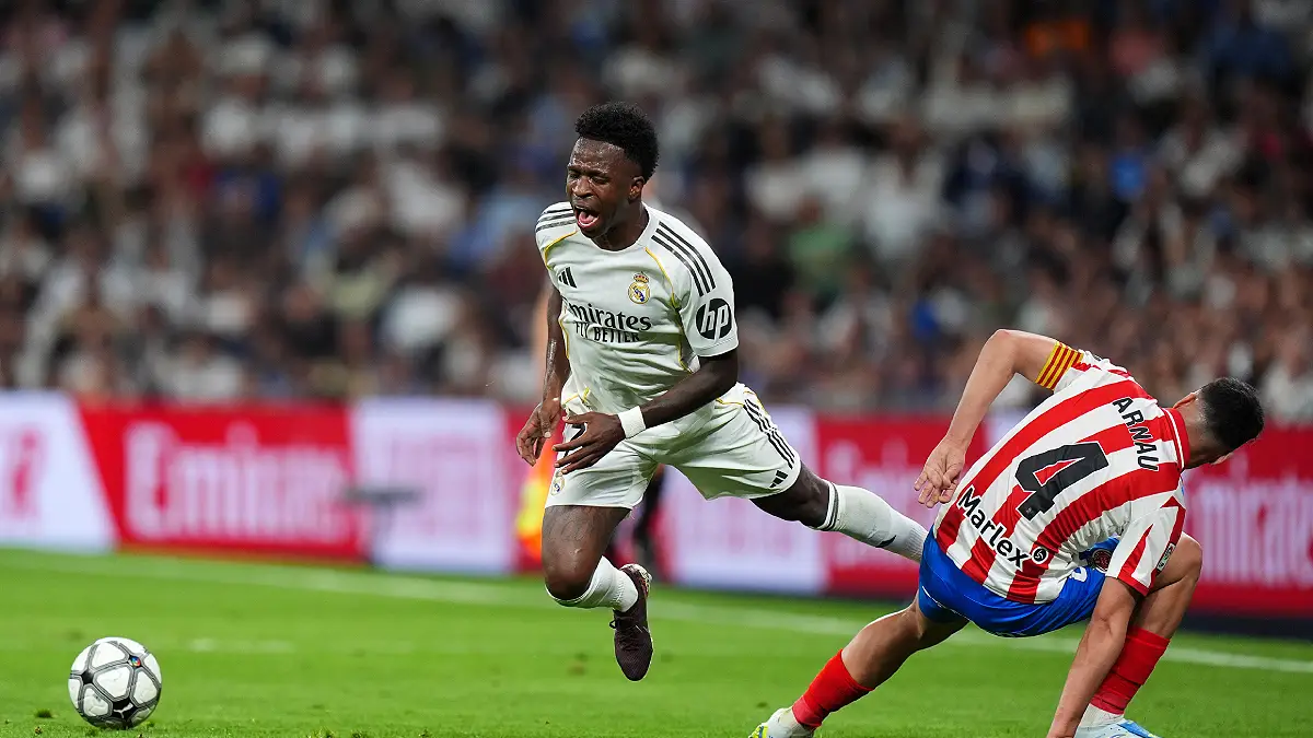 MADRID, SPAIN - APRIL 10: Vinicius Junior of Real Madrid is challenged by Arnau Martinez of Girona FC during the LaLiga EA Sports match between Real Madrid CF and Girona FC at Estadio Santiago Bernabeu on April 10, 2026 in Madrid, Spain. (Photo by Angel Martinez/Getty Images)