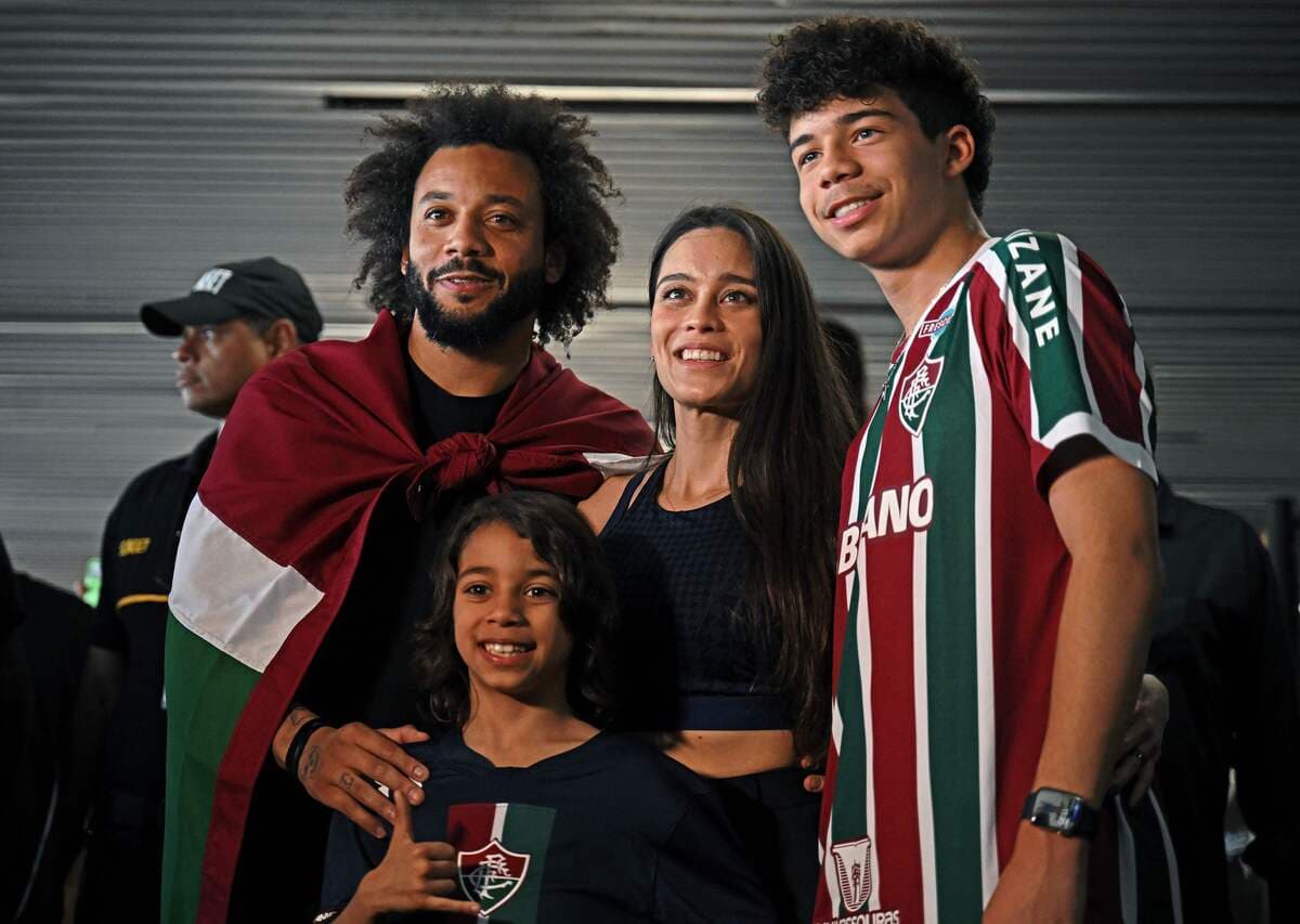 Brazilian defender Marcelo, wrapped in a flag of Brazilian team Fluminense, poses with his wife Clarise Alves and their sons Enzo (R) and Liam upon arriving at Galeao Airport in Rio de Janeiro, Brazil, on March 9, 2023, on the eve of his official presentation. - Marcelo, five-time European champion with Real Madrid, signed with Fluminense until December 2024. (Photo by Carl DE SOUZA / AFP) (Photo by CARL DE SOUZA/AFP via Getty Images)