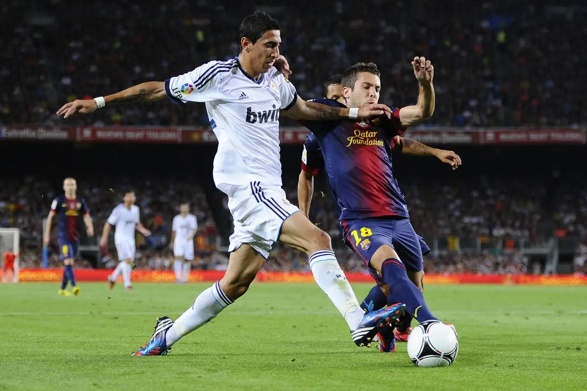 BARCELONA, SPAIN - AUGUST 23: Angel Di Maria of Real Madrid CF duels for the ball with Jordi Alba of FC Barcelona during the Super Cup first leg match between FC Barcelona and Real Madrid at Camp Nou on August 23, 2012 in Barcelona, Spain. (Photo by David Ramos/Getty Images)