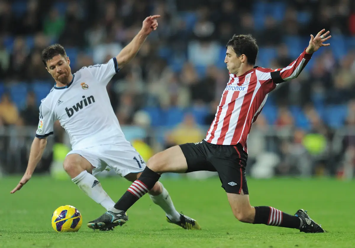 MADRID, SPAIN - NOVEMBER 17: Iker Munian (R) of Athletic Club battles for the ball against Xabi Alonso of Real Madrid during the La Liga match between Real Madrid CF and Athletic Club de Bilbao at estadio Santiago Bernabeu on November 17, 2012 in Madrid, Spain. (Photo by Denis Doyle/Getty Images)