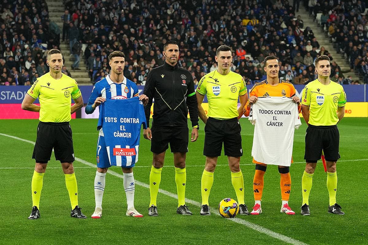 BARCELONA, SPAIN - FEBRUARY 01: Javi Puado of RCD Espanyol and Lucas Vazquez of Real Madrid pose for a photo with match officials with shirts that read "All Together Against Cancer" during the LaLiga match between RCD Espanyol de Barcelona and Real Madrid CF at RCDE Stadium on February 01, 2025 in Barcelona, Spain. (Photo by Alex Caparros/Getty Images)