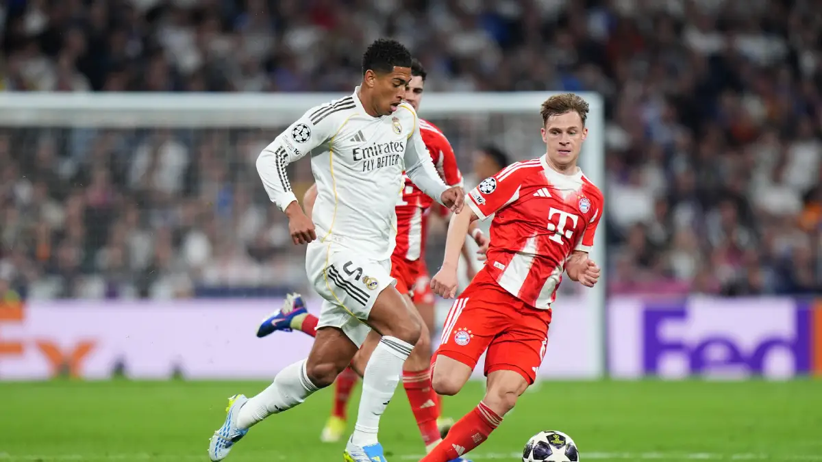 MADRID, SPAIN - APRIL 07: Jude Bellingham of Real Madrid runs with the ball while under pressure from Joshua Kimmich of FC Bayern Munich during the UEFA Champions League 2025/26 Quarter-Final First Leg match between Real Madrid CF and FC Bayern München at Estadio Santiago Bernabeu on April 07, 2026 in Madrid, Spain. (Photo by Angel Martinez/Getty Images)
