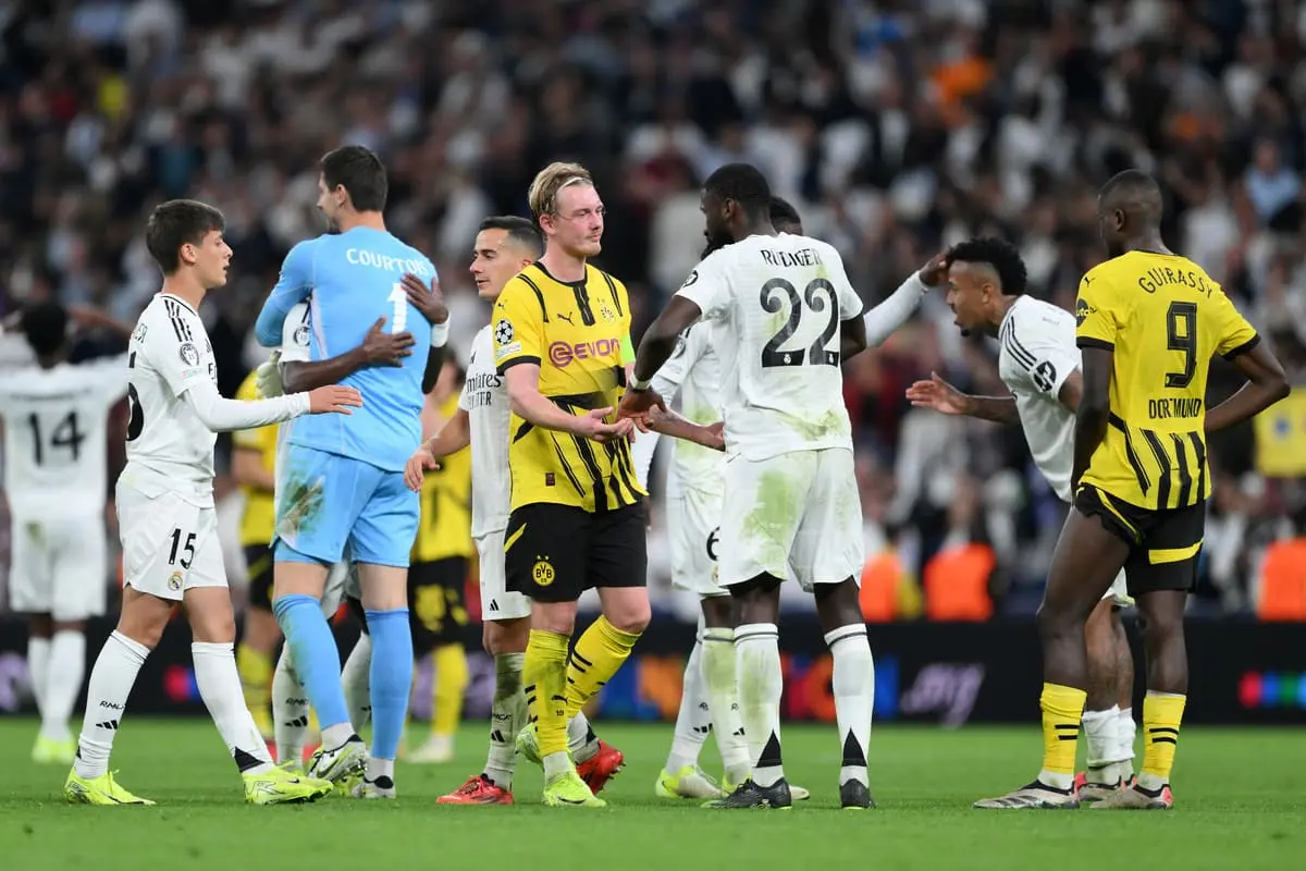 MADRID, SPAIN - OCTOBER 22: Julian Brandt of Borussia Dortmund and Antonio Ruediger of Real Madrid interact at full-time following the UEFA Champions League 2024/25 League Phase MD3 match between Real Madrid C.F. and Borussia Dortmund at Estadio Santiago Bernabeu on October 22, 2024 in Madrid, Spain. (Photo by David Ramos/Getty Images)