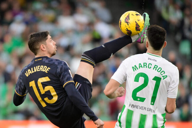 Real Madrid's Uruguayan midfielder #15 Federico Valverde fights for the ball with Real Betis' Spanish midfielder #21 Marc Roca during the Spanish league football match between Real Betis and Real Madrid CF at the Benito Villamarin stadium in Seville on December 9, 2023. (Photo by CRISTINA QUICLER / AFP) (Photo by CRISTINA QUICLER/AFP via Getty Images)
