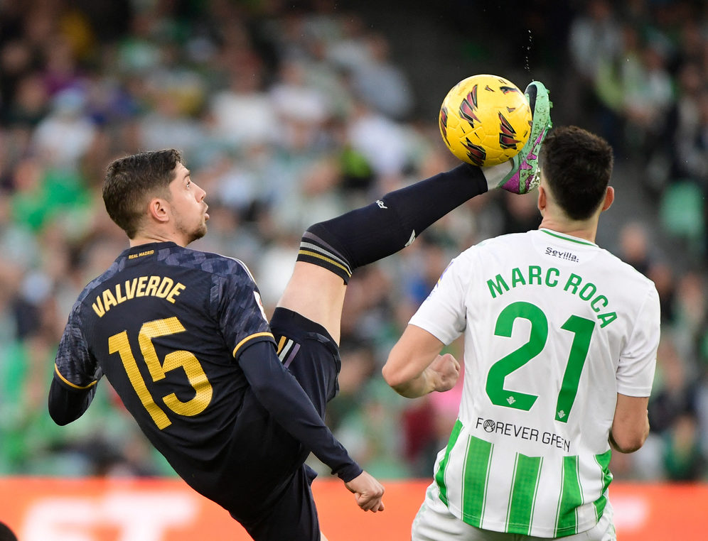 Real Madrid's Uruguayan midfielder #15 Federico Valverde fights for the ball with Real Betis' Spanish midfielder #21 Marc Roca during the Spanish league football match between Real Betis and Real Madrid CF at the Benito Villamarin stadium in Seville on December 9, 2023. (Photo by CRISTINA QUICLER / AFP) (Photo by CRISTINA QUICLER/AFP via Getty Images)