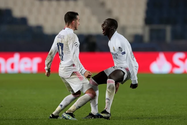 BERGAMO, ITALY - FEBRUARY 24: Ferland Mendy of Real Madrid celebrates with team mate Lucas Vazquez (L) after scoring their side's first goal during the UEFA Champions League Round of 16 match between Atalanta and Real Madrid at Gewiss Stadium on February 24, 2021 in Bergamo, Italy. Sporting stadiums around Italy remain under strict restrictions due to the Coronavirus Pandemic as Government social distancing laws prohibit fans inside venues resulting in games being played behind closed doors (Ancelotti). (Photo by Emilio Andreoli/Getty Images).