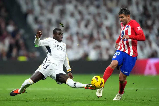 MADRID, SPAIN - FEBRUARY 04: Angel Correa of Atletico Madrid is tackled by Ferland Mendy of Real Madrid during the LaLiga EA Sports match between Real Madrid CF and Atletico Madrid at Estadio Santiago Bernabeu on February 04, 2024 in Madrid, Spain. (Photo by Angel Martinez/Getty Images).