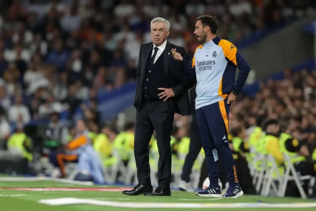 MADRID, SPAIN - SEPTEMBER 24: Manager Carlo Ancelotti (L) of Real Madrid CF speaks with his assistant coach Davide Ancelotti (R) during the LaLiga match between Real Madrid CF and Deportivo Alaves at Estadio Santiago Bernabeu on September 24, 2024 in Madrid, Spain. (Photo by Gonzalo Arroyo Moreno/Getty Images).