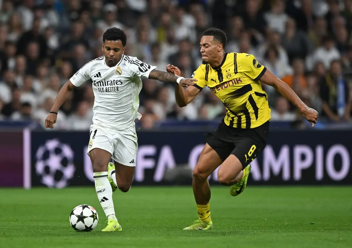 MADRID, SPAIN - OCTOBER 22: Rodrygo of Real Madrid runs with the ball whilst under pressure from Felix Nmecha of Borussia Dortmund during the UEFA Champions League 2024/25 League Phase MD3 match between Real Madrid C.F. and Borussia Dortmund at Estadio Santiago Bernabeu on October 22, 2024 in Madrid, Spain. (Photo by Denis Doyle/Getty Images).