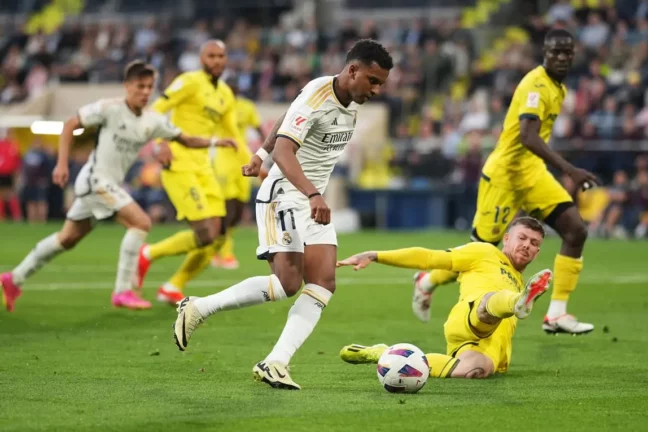 VILLARREAL, SPAIN - MAY 19: Rodrygo of Real Madrid runs with the ball whilst under pressure from Alberto Moreno of Villarreal CF during the LaLiga EA Sports match between Villarreal CF and Real Madrid CF at Estadio de la Ceramica on May 19, 2024 in Villarreal, Spain. (Photo by Alex Caparros/Getty Images).