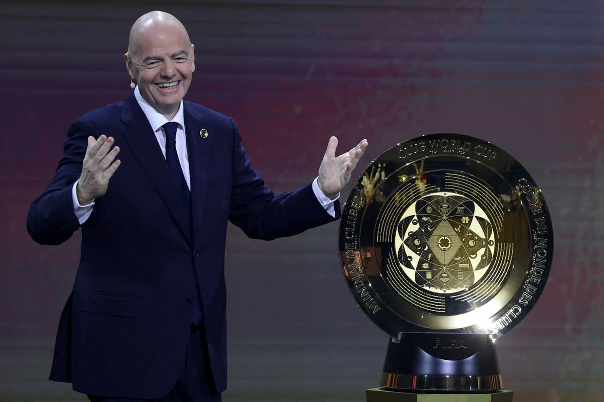 Gianni Infantino, le président de la FIFA, avec le trophée du Mondial des Clubs lors du tirage au sort à Miami (Photo by Brennan Asplen/Getty Images)
