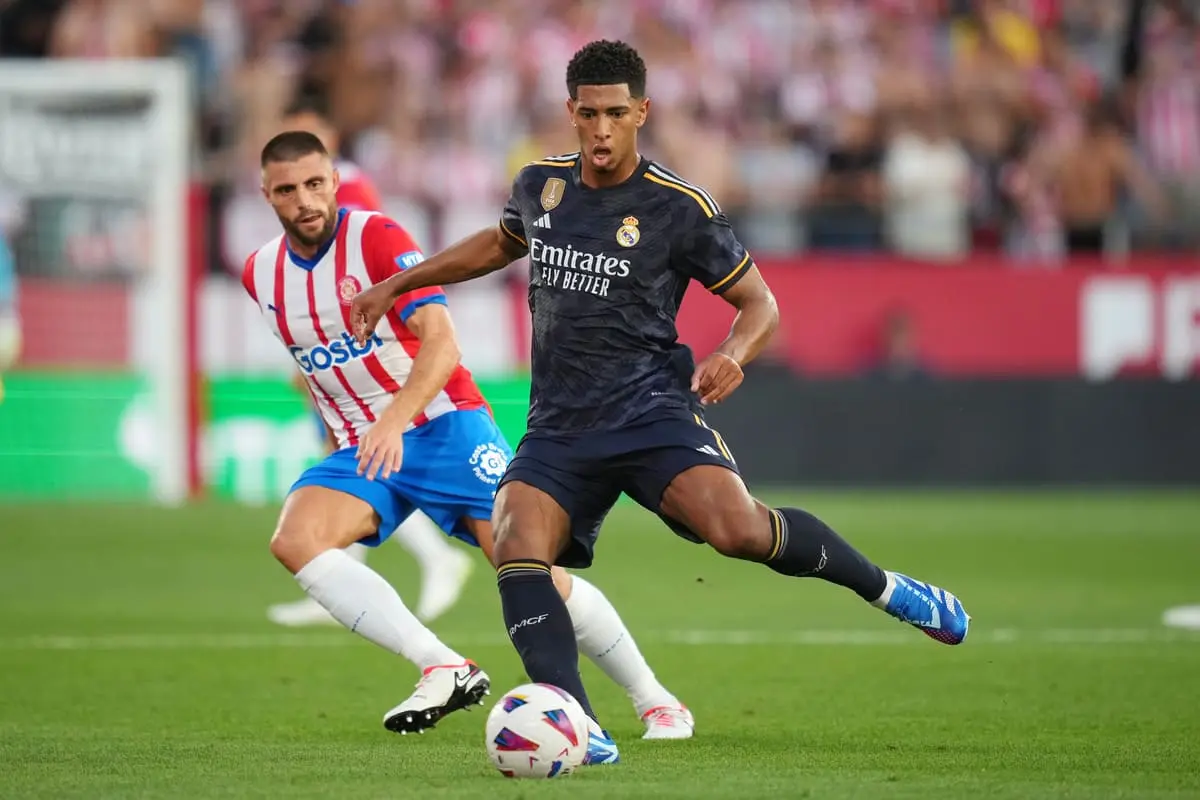 GIRONA, SPAIN - SEPTEMBER 30: Jude Bellingham of Real Madrid controls the ball whilst under pressure from David Lopez of Girona during the LaLiga EA Sports match between Girona FC and Real Madrid CF at Montilivi Stadium on September 30, 2023 in Girona, Spain. (Photo by Alex Caparros/Getty Images)