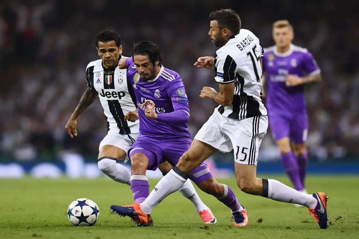 CARDIFF, WALES - JUNE 03: Isco of Real Madrid is fouled by Dani Alves of Juventus and Andrea Barzagli of Juventus during the UEFA Champions League Final between Juventus and Real Madrid at National Stadium of Wales on June 3, 2017 in Cardiff, Wales. (Photo by David Ramos/Getty Images)