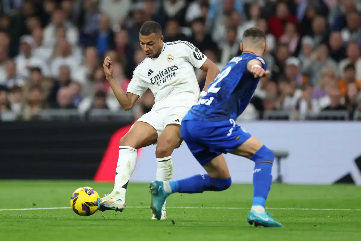 MADRID, SPAIN - DECEMBER 01: Kylian Mbappe of Real Madrid shoots whilst under pressure from Domingos Duarte of Getafe CF during the LaLiga match between Real Madrid CF and Getafe CF at Estadio Santiago Bernabeu on December 01, 2024 in Madrid, Spain. (Photo by Florencia Tan Jun/Getty Images)