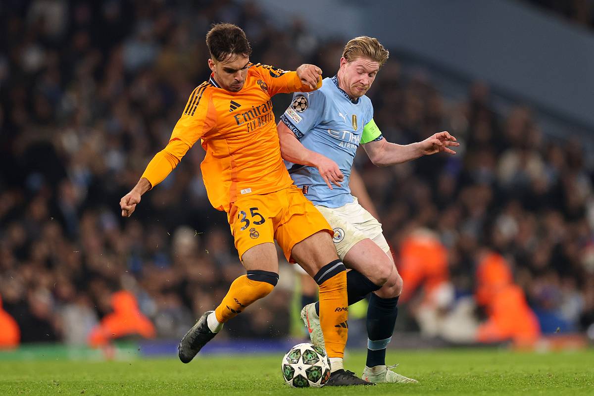 MANCHESTER, ENGLAND - FEBRUARY 11: Raul Asencio of Real Madrid is challenged by Kevin De Bruyne of Manchester City during the UEFA Champions League 2024/25 League Knockout Play-off first leg match between Manchester City and Real Madrid C.F. at Manchester City Stadium on February 11, 2025 in Manchester, England. (Photo by Carl Recine/Getty Images)