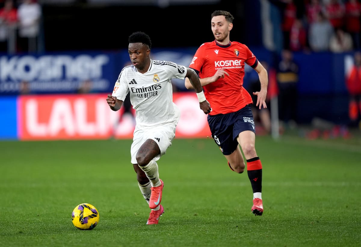 PAMPLONA, SPAIN - FEBRUARY 15: Vinicius Junior of Real Madrid runs with the ball whilst under pressure from Raul Garcia of CA Osasuna during the LaLiga match between CA Osasuna and Real Madrid CF at Estadio El Sadar on February 15, 2025 in Pamplona, Spain. (Photo by Juan Manuel Serrano Arce/Getty Images)