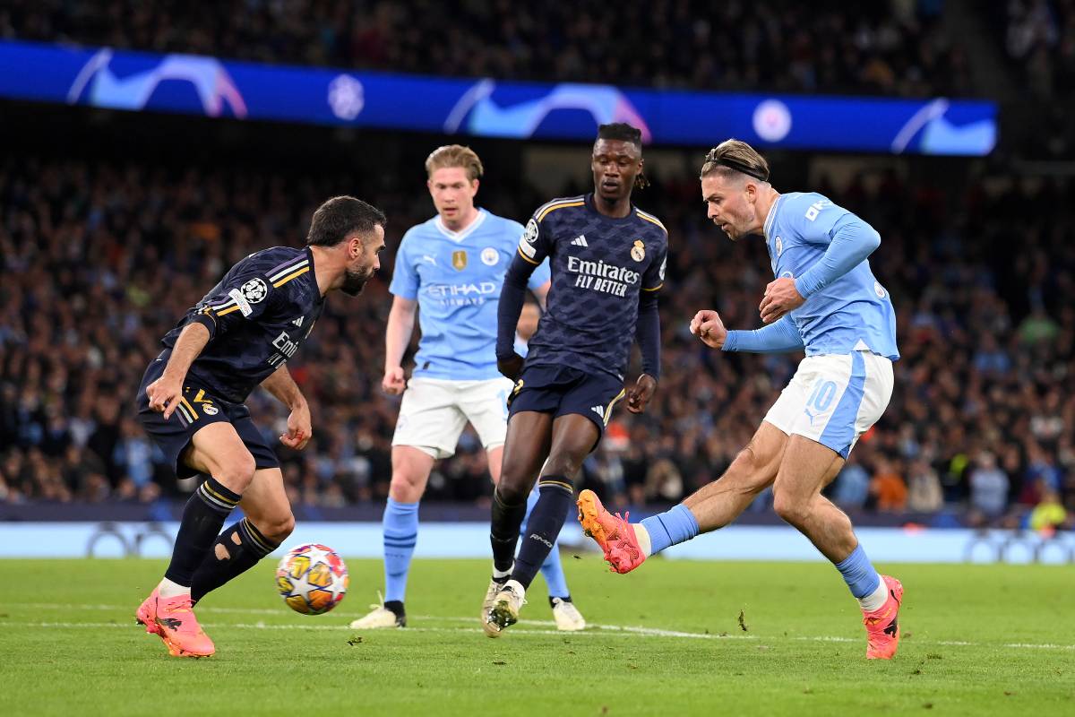 MANCHESTER, ENGLAND - APRIL 17: Jack Grealish of Manchester City shoots whilst under pressure from Daniel Carvajal and Eduardo Camavinga of Real Madrid during the UEFA Champions League quarter-final second leg match between Manchester City and Real Madrid CF at Etihad Stadium on April 17, 2024 in Manchester, England. (Photo by Stu Forster/Getty Images)