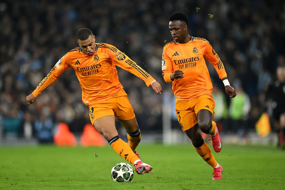 MANCHESTER, ENGLAND - FEBRUARY 11: Kylian Mbappe of Real Madrid runs with the ball alongside team mate Vinicius Junior during the UEFA Champions League 2024/25 League Knockout Play-off first leg match between Manchester City and Real Madrid C.F. at Manchester City Stadium on February 11, 2025 in Manchester, England. (Photo by Michael Regan/Getty Images)