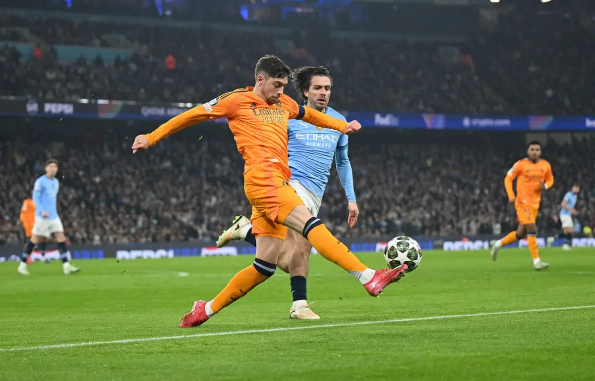 MANCHESTER, ENGLAND - FEBRUARY 11: Federico Valverde of Real Madrid makes a pass whilst under pressure from Jack Grealish of Manchester City during the UEFA Champions League 2024/25 League Knockout Play-off first leg match between Manchester City and Real Madrid C.F. at Manchester City Stadium on February 11, 2025 in Manchester, England. (Photo by Michael Regan/Getty Images).