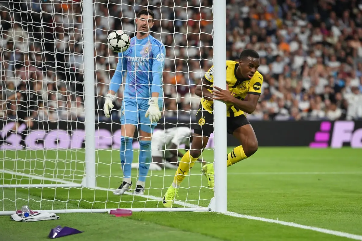 MADRID, SPAIN - OCTOBER 22: Jamie Bynoe-Gittens of Borussia Dortmund celebrates scoring his team's second goal as Thibaut Courtois of Real Madrid looks on during the UEFA Champions League 2024/25 League Phase MD3 match between Real Madrid C.F. and Borussia Dortmund at Estadio Santiago Bernabeu on October 22, 2024 in Madrid, Spain. (Photo by Denis Doyle/Getty Images)