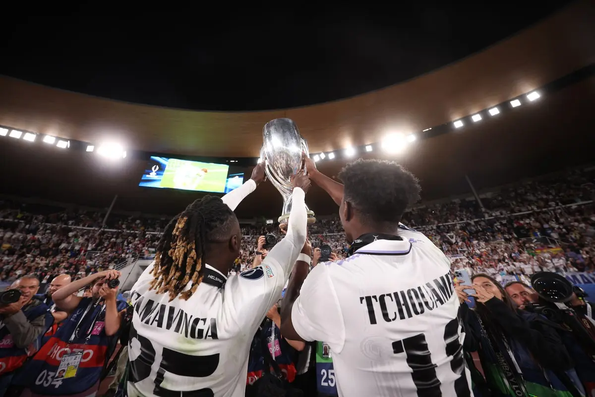 HELSINKI, FINLAND - AUGUST 10: Eduardo Camavinga and Aurelien Tchouameni of Real Madrid lift the UEFA Super Cup trophy in front of their fans after the final whistle of the UEFA Super Cup Final 2022 between Real Madrid CF and Eintracht Frankfurt at Helsinki Olympic Stadium on August 10, 2022 in Helsinki, Finland. (Photo by Alex Grimm/Getty Images )