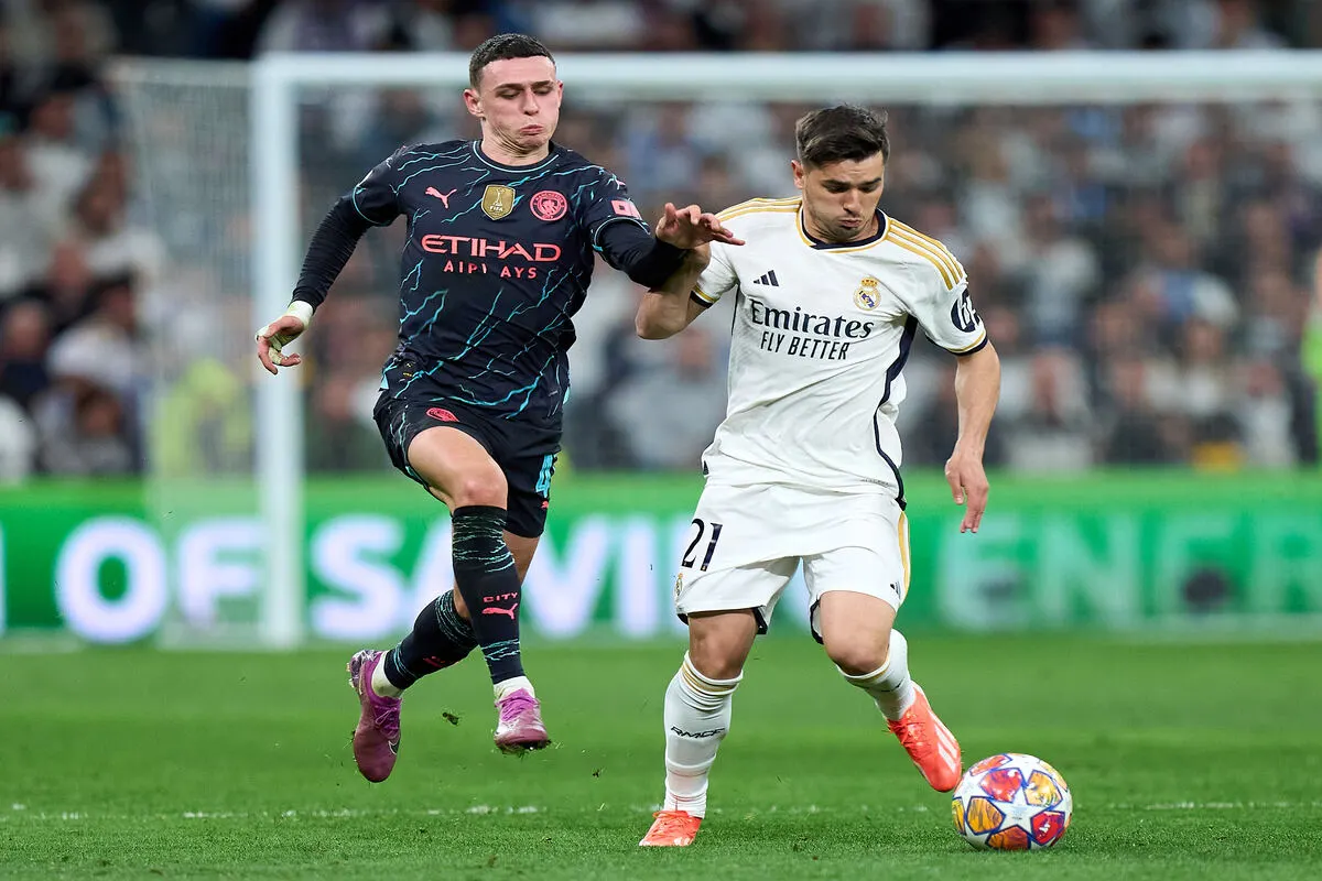 MADRID, SPAIN - APRIL 09: Brahim Diaz of Real Madrid is challenged by Phil Foden of Manchester City during the UEFA Champions League quarter-final first leg match between Real Madrid CF and Manchester City at Estadio Santiago Bernabeu on April 09, 2024 in Madrid, Spain. (Photo by Angel Martinez/Getty Images)