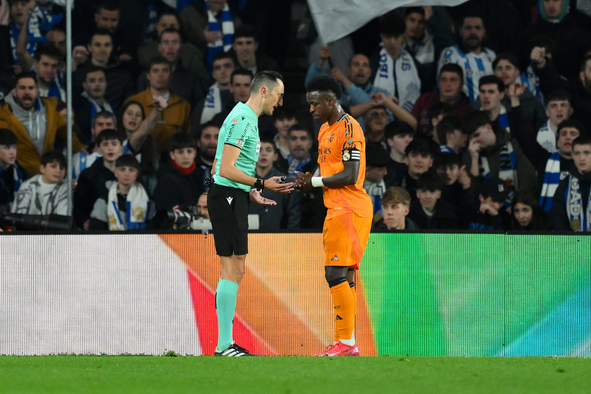 SAN SEBASTIAN, SPAIN - FEBRUARY 26: Vinicius Junior of Real Madrid talks to Referee, Jose Maria Sanchez Martinez in front of Real Sociedad fans during the Copa del Rey Semi Final match between Real Sociedad and Real Madrid at Reale Arena on February 26, 2025 in San Sebastian, Spain. (Photo by David Ramos/Getty Images)