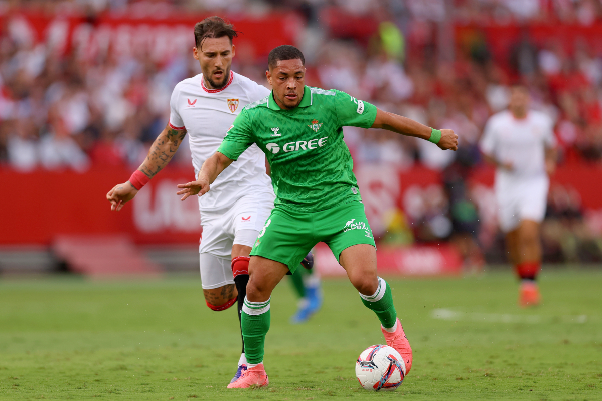 SEVILLE, SPAIN - OCTOBER 06: Vitor Roque of Real Betis runs with the ball under pressure from Nemanja Gudelj of Sevilla FC during the LaLiga match between Sevilla FC and Real Betis Balompie at Estadio Ramon Sanchez Pizjuan on October 06, 2024 in Seville, Spain. (Photo by Fran Santiago/Getty Images)