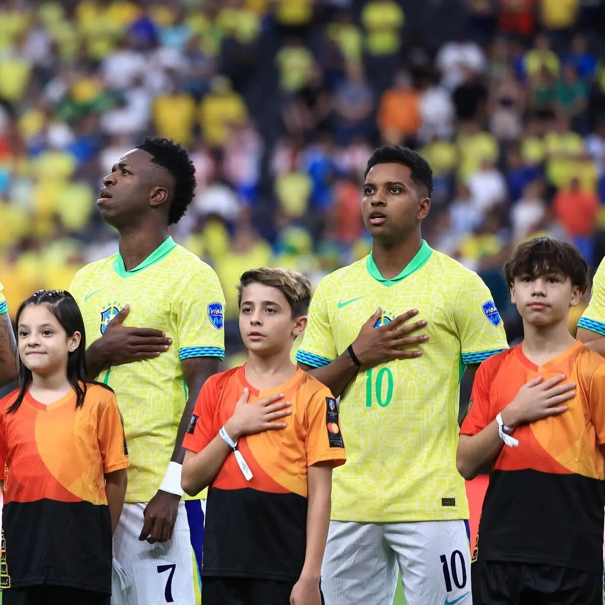 LAS VEGAS, NEVADA - JUNE 28: Eder Militao, Vinicius Junior and Rodrygo of Brazil line up for the national anthem prior to the CONMEBOL Copa America 2024 Group D match between Paraguay and Brazil at Allegiant Stadium on June 28, 2024 in Las Vegas, Nevada. (Photo by Buda Mendes/Getty Images).