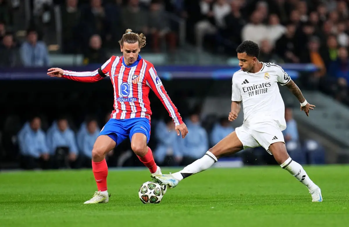 MADRID, SPAIN - MARCH 04: Rodrygo of Real Madrid battles for possession with Antoine Griezmann of Atletico de Madrid during the UEFA Champions League 2024/25 Round of 16 first leg match between Real Madrid C.F. and Atletico de Madrid at Santiago Bernabeu Stadium on March 04, 2025 in Madrid, Spain. (Photo by Aitor Alcalde/Getty Images).