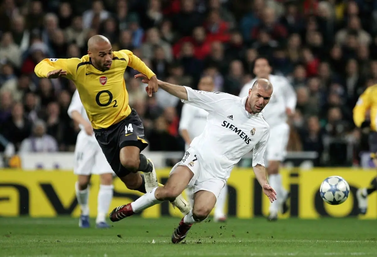 MADRID, SPAIN - FEBRUARY 21: Thierry Henry of Arsenal tackles Zinedine Zidane of Madrid during the UEFA Champions League Round of 16, First Leg match between Real Madrid and Arsenal at the Santiago Bernabeu Stadium on February 21, 2006 in Madrid, Spain. (Photo by Richard Heathcote/Getty Images).