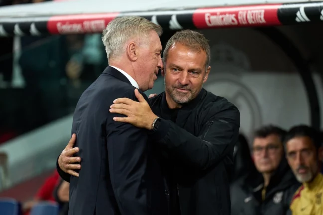 MADRID, SPAIN - OCTOBER 26: Hansi Flick, Head Coach of FC Barcelona, interacts with Carlo Ancelotti, Head Coach of Real Madrid, prior to he LaLiga match between Real Madrid CF and FC Barcelona at Estadio Santiago Bernabeu on October 26, 2024 in Madrid, Spain. (Photo by Angel Martinez/Getty Images) Clásico