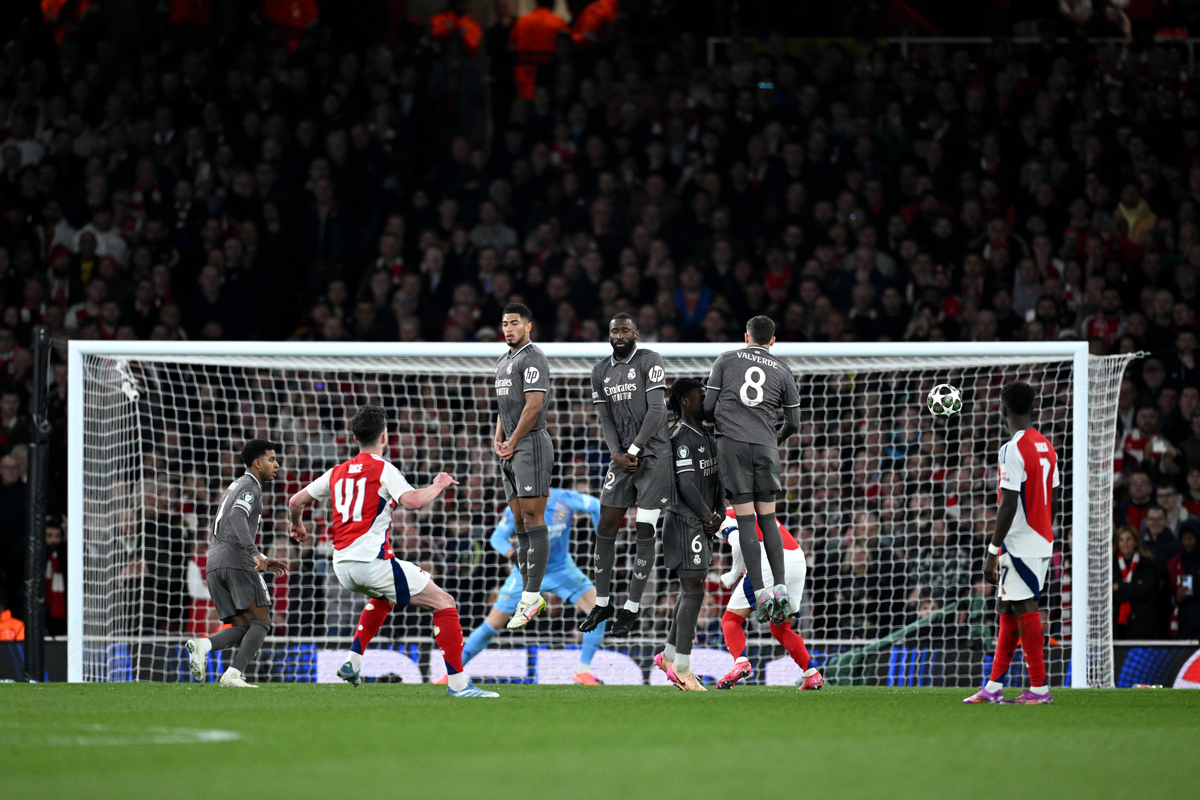LONDON, ENGLAND - APRIL 08: Declan Rice of Arsenal scores his team's first goal from a free kick as Jude Bellingham, Antonio Ruediger, Eduardo Camavinga and Federico Valverde of Real Madrid jump in a defensive wall during the UEFA Champions League 2024/25 Quarter Final