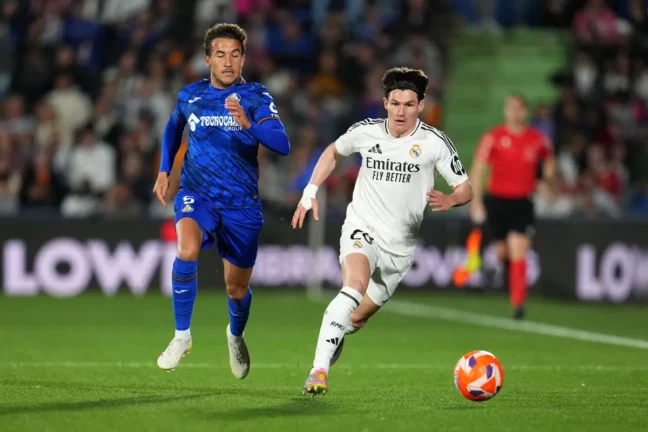 GETAFE, SPAIN - APRIL 23: Fran Garcia of Real Madrid runs with the ball under pressure from Luis Milla of Getafe CF during the LaLiga match between Getafe CF and Real Madrid CF at Coliseum Alfonso Perez on April 23, 2025 in Getafe, Spain. (Photo by Aitor Alcalde/Getty Images)