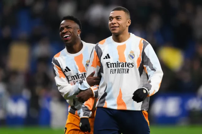 BARCELONA, SPAIN - FEBRUARY 01: Vinicius Junior and Kylian Mbappe of Real Madrid smile on pitch prior to the LaLiga match between RCD Espanyol de Barcelona and Real Madrid CF at RCDE Stadium on February 01, 2025 in Barcelona, Spain. (Photo by David Ramos/Getty Images)