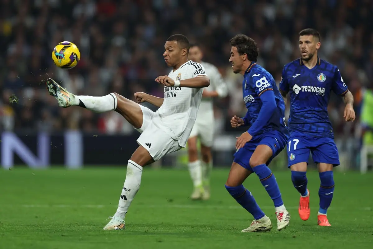 MADRID, SPAIN - DECEMBER 01: Kylian Mbappe of Real Madrid controls the ball whilst under pressure from Luis Milla of Getafe CF during the LaLiga match between Real Madrid CF and Getafe CF at Estadio Santiago Bernabeu on December 01, 2024 in Madrid, Spain. (Photo by Florencia Tan Jun/Getty Images)