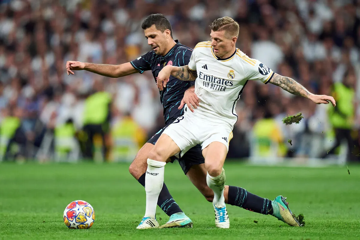MADRID, SPAIN - APRIL 09: Rodrigo Hernandez of Manchester City is challenged by Toni Kroos of Real Madrid during the UEFA Champions League quarter-final first leg match between Real Madrid CF and Manchester City at Estadio Santiago Bernabeu on April 09, 2024 in Madrid, Spain. (Photo by Angel Martinez/Getty Images)