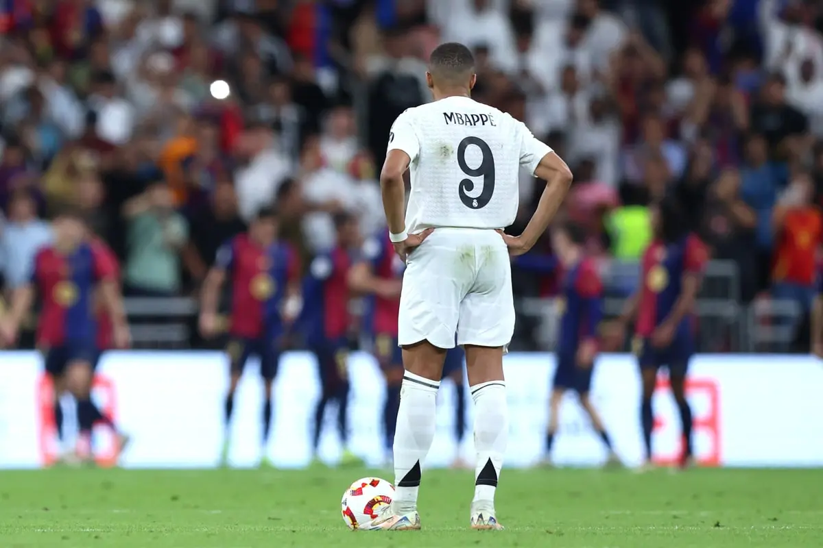 JEDDAH, SAUDI ARABIA - JANUARY 12: Kylian Mbappe of Real Madrid reacts as Raphinha of FC Barcelona (obscured)celebrates scoring his team's third goal during the Spanish Super Cup Final between Real Madrid and FC Barcelona at King Abdullah Sports City on January 12, 2025 in Jeddah, Saudi Arabia. (Photo by Yasser Bakhsh/Getty Images)