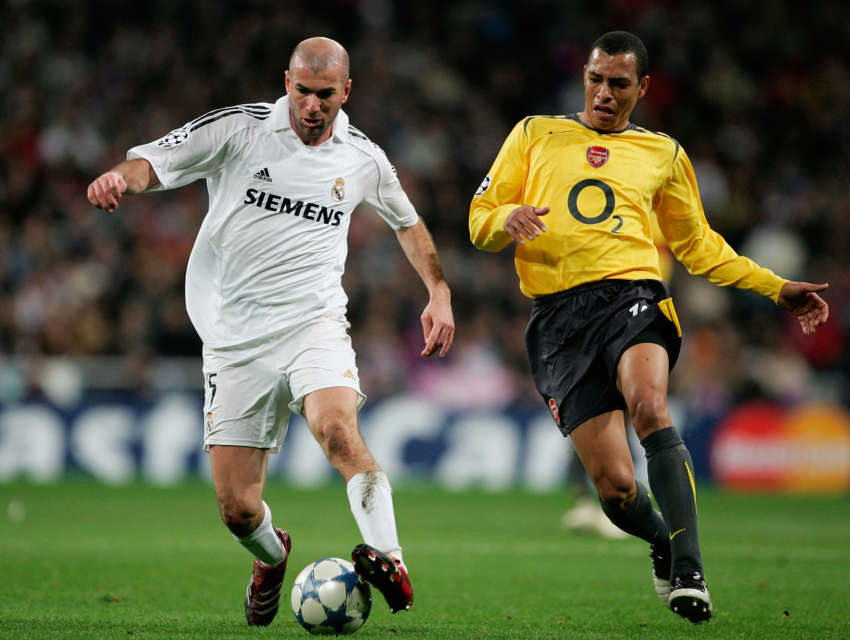 MADRID, SPAIN - FEBRUARY 21: Gilberto of Arsenal chases down Zinedine Zidane of Madrid during the UEFA Champions League Round of 16, First Leg match between Real Madrid and Arsenal at the Santiago Bernabeu Stadium on February 21, 2006 in Madrid, Spain. (Photo by Richard Heathcote/Getty Images)