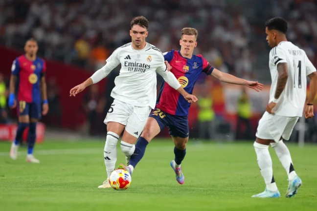 SEVILLE, SPAIN - APRIL 26: Raul Asencio of Real Madrid is challenged by Dani Olmo of FC Barcelona during the Copa del Rey Final match between FC Barcelona and Real Madrid at Estadio de La Cartuja on April 26, 2025 in Seville, Spain. (Photo by Fran Santiago/Getty Images)
