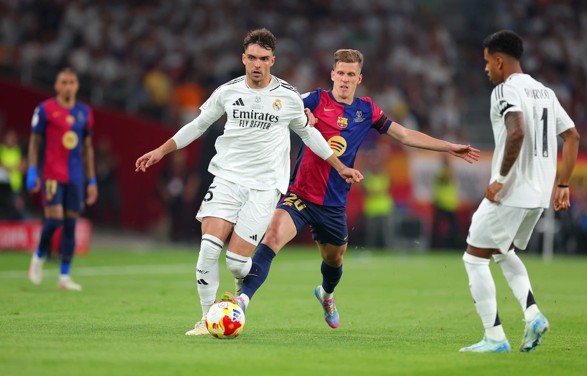 SEVILLE, SPAIN - APRIL 26: Raul Asencio of Real Madrid is challenged by Dani Olmo of FC Barcelona during the Copa del Rey Final match between FC Barcelona and Real Madrid at Estadio de La Cartuja on April 26, 2025 in Seville, Spain. (Photo by Fran Santiago/Getty Images)