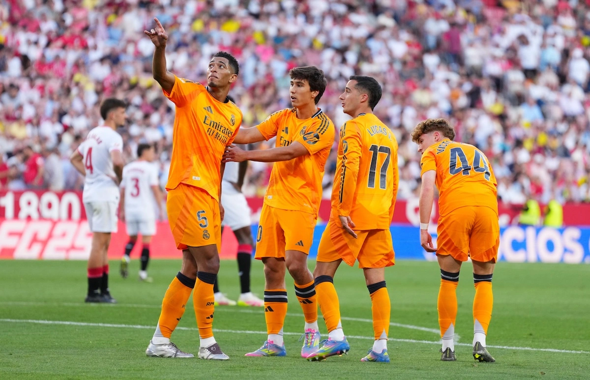 SEVILLE, SPAIN - MAY 18: Jude Bellingham of Real Madrid celebrates scoring his team's second goal with teammates Gonzalo Garcia (Fabrica) and Lucas Vazquez during the LaLiga match between Sevilla FC and Real Madrid CF at Estadio Ramon Sanchez Pizjuan on May 18, 2025 in Seville, Spain. (Photo by Angel Martinez/Getty Images)