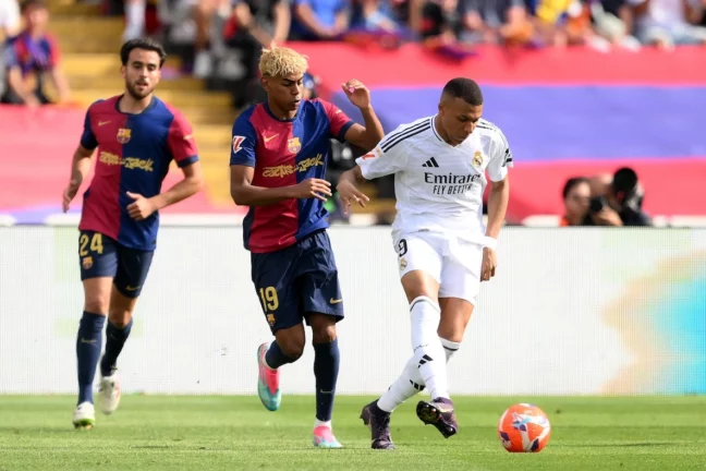BARCELONA, SPAIN - MAY 11: Kylian Mbappe of Real Madrid passes the ball under pressure from Lamine Yamal of FC Barcelona during the LaLiga match between FC Barcelona and Real Madrid CF at Estadi Olimpic Lluis Companys on May 11, 2025 in Barcelona, Spain. (Photo by David Ramos/Getty Images)
