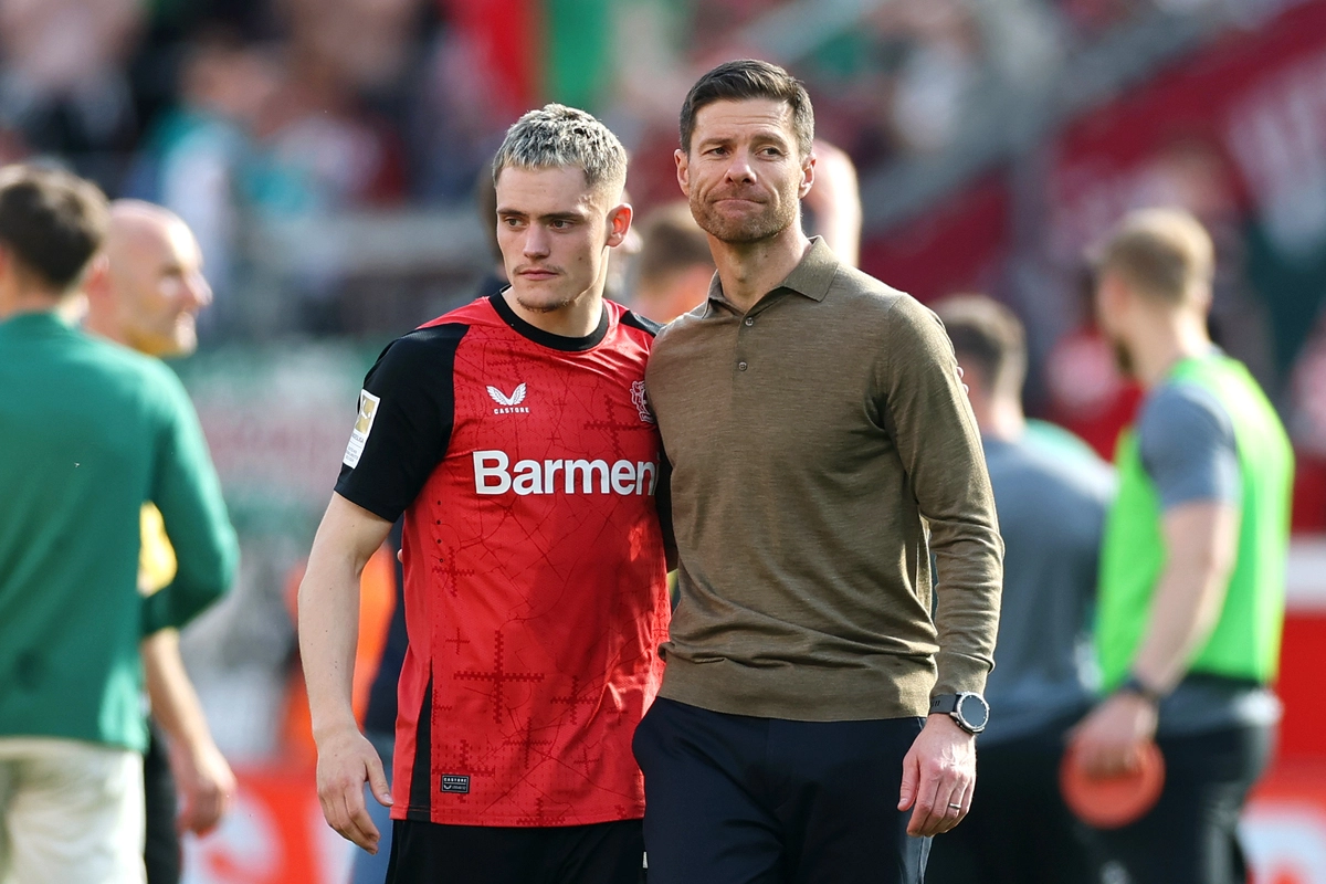 LEVERKUSEN, GERMANY - APRIL 26: Florian Wirtz of Bayer 04 Leverkusen embraces Xabi Alonso, Head Coach of Bayer 04 Leverkusen, after the Bundesliga match between Bayer 04 Leverkusen and FC Augsburg at BayArena on April 26, 2025 in Leverkusen, Germany. (Photo by Lars