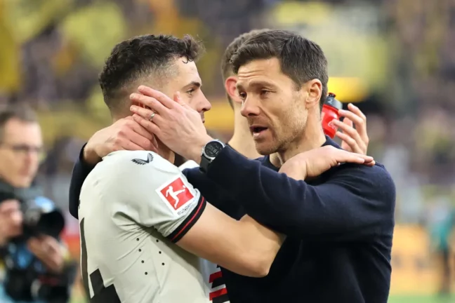 DORTMUND, GERMANY - APRIL 21: Xabi Alonso, Head Coach of Bayer Leverkusen, and Granit Xhaka of Bayer Leverkusen celebrates following the team's victory in the Bundesliga match between Borussia Dortmund and Bayer 04 Leverkusen at Signal Iduna Park on April 21, 2024 in Dortmund, Germany. (Photo by Christof Koepsel/Getty Images)