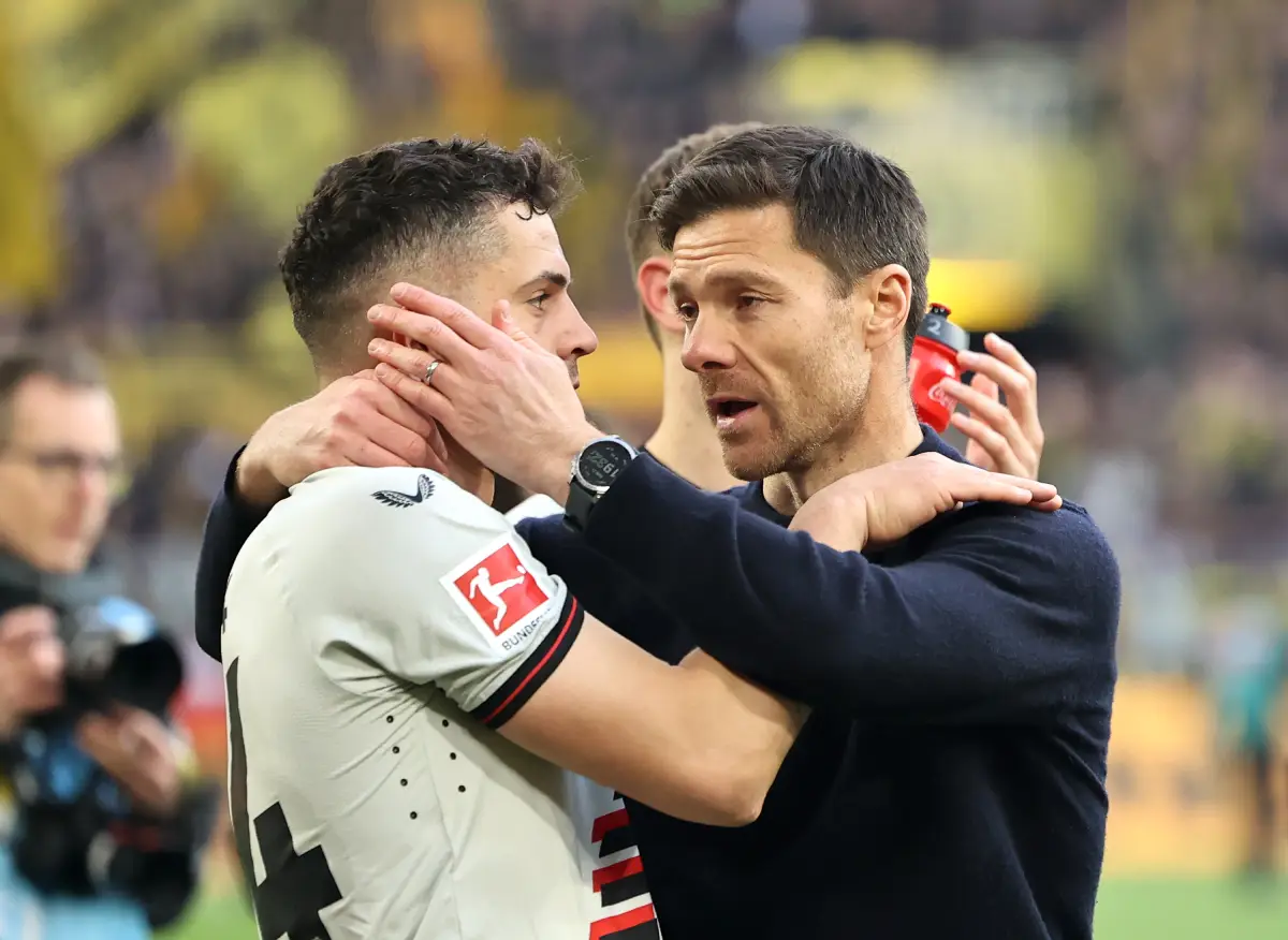 DORTMUND, GERMANY - APRIL 21: Xabi Alonso, Head Coach of Bayer Leverkusen, and Granit Xhaka of Bayer Leverkusen celebrates following the team's victory in the Bundesliga match between Borussia Dortmund and Bayer 04 Leverkusen at Signal Iduna Park on April 21, 2024 in Dortmund, Germany. (Photo by Christof Koepsel/Getty Images)