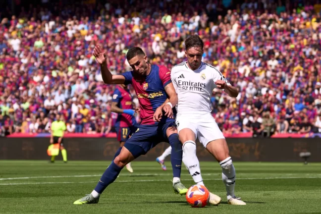 BARCELONA, SPAIN - MAY 11: Ferran Torres of FC Barcelona fights for the ball with Raul Asencio of Real Madrid CF during the LaLiga match between FC Barcelona and Real Madrid CF at Estadi Olimpic Lluis Companys on May 11, 2025 in Barcelona, Spain. (Photo by Alex Caparros/Getty Images)