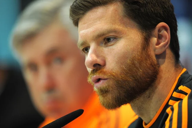 MADRID, SPAIN - APRIL 22: Xabi Alonso (R) of Real Madrid CF answers a question beside head coach Carlo Ancelotti during their press conference at Valdebebas training ground ahead of the UEFA Champions League semi-final first leg match against Bayern Munich on April 22, 2014 in Madrid, Spain. (Photo by Denis Doyle/Getty Images)